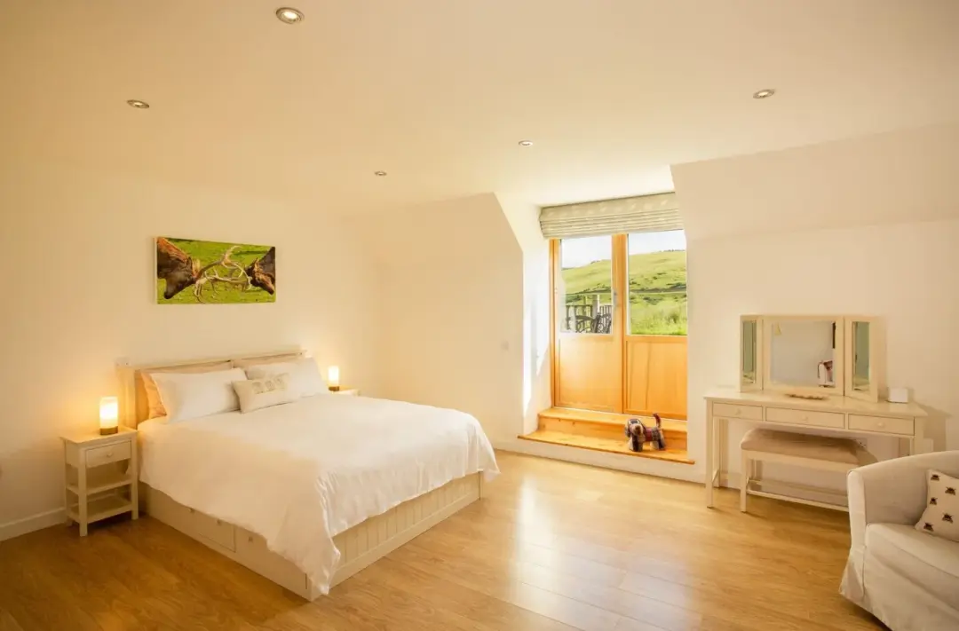 Master bedroom at The Mill with a king-size bed and glazed patio doors